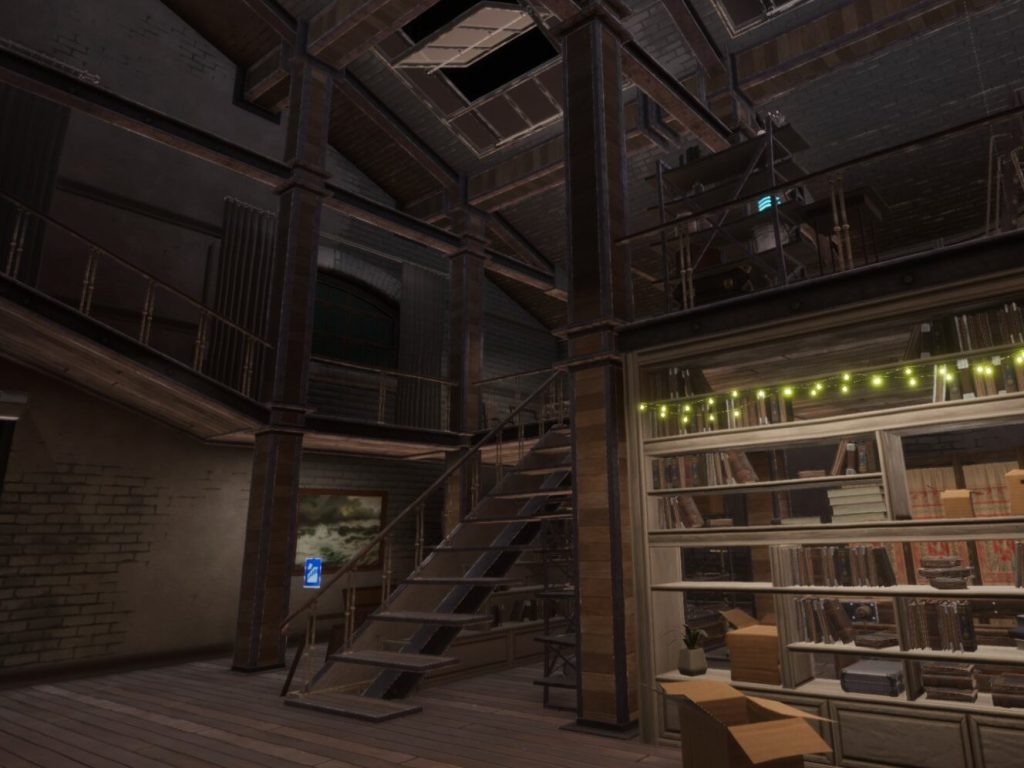 A view of an industrial looking building interior with bookshelves, stairs, upper railings, and other items cluttered about.